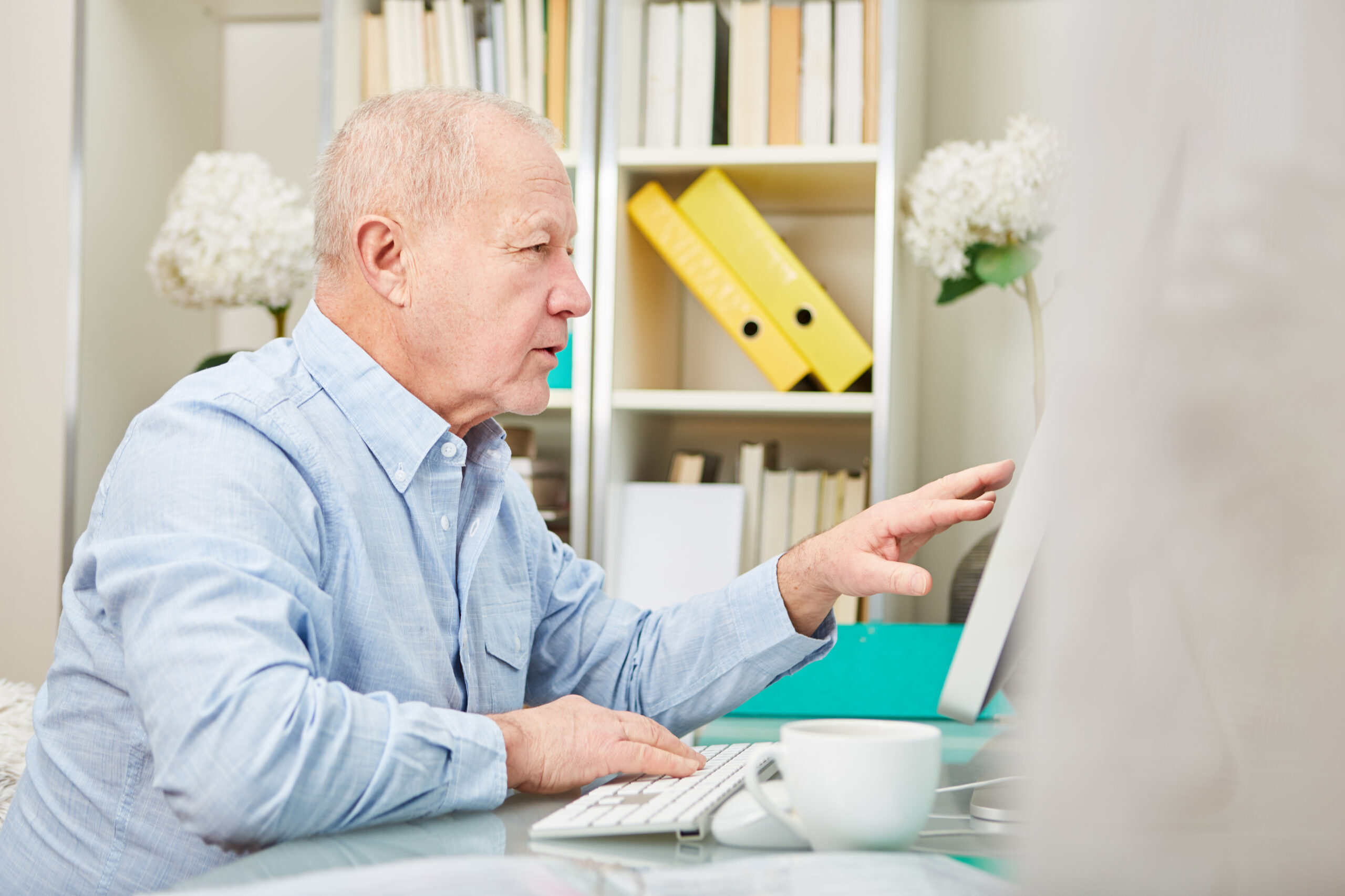 Älterer Business Mann am Computer Monitor recherchiert im Internet